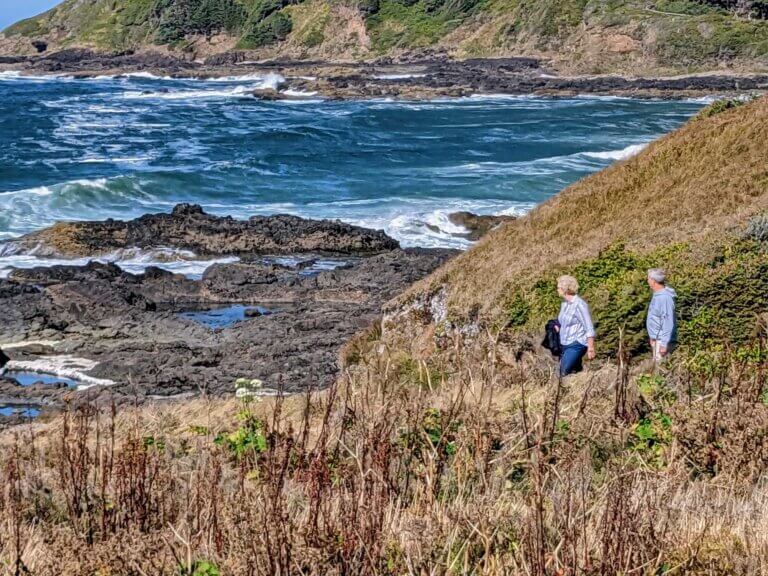 A couple walks and contemplates the tide at Cape Perpetua