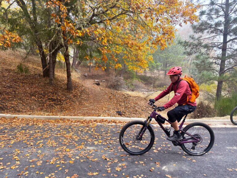 A man rides a mountain bike across a parking lot